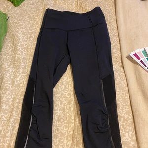 Lululemon size two capri leggings. Navy blue with mesh around bottom.